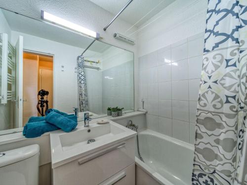 une salle de bain avec un lavabo, une baignoire et un miroir dans l'établissement Studio Soyouz Vanguard-98 by Interhome, au Corbier
