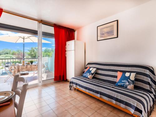 une chambre avec un lit et une porte coulissante en verre dans l'établissement Studio Le Lagon Bleu-4 by Interhome, au Grau-du-Roi