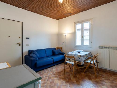 a living room with a blue couch and a table at Holiday Home Calderina by Interhome in Imperia
