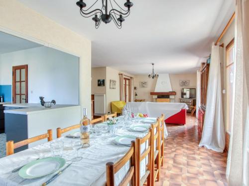 ein Esszimmer mit einem langen Tisch und einer Küche in der Unterkunft Holiday Home L'Arbousier by Interhome in Six-Fours-les-Plages