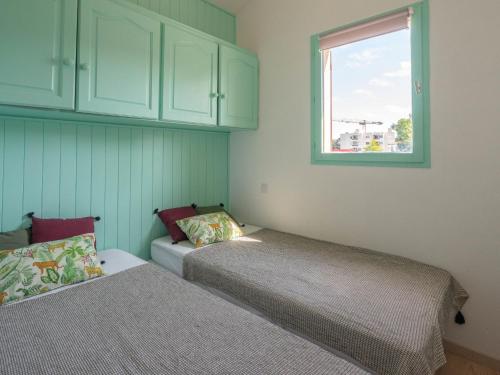 une chambre avec deux lits et une fenêtre dans l'établissement Holiday Home Les Jardins de la Palmyre-3 by Interhome, aux Mathes