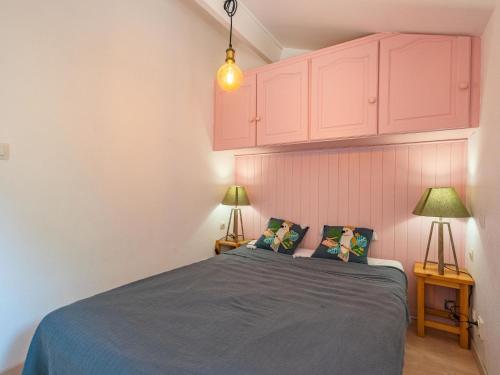 a bedroom with a bed with pink cabinets and two lamps at Holiday Home Les Jardins de la Palmyre-3 by Interhome in Les Mathes