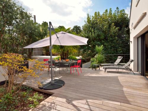 un patio avec une table et un parasol dans l'établissement Holiday Home La Rose des Sables by Interhome, à Pornichet