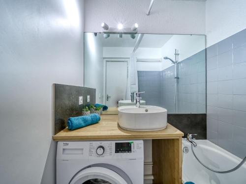 une salle de bain avec un lavabo et une machine à laver dans l'établissement Apartment Pegase Phenix-74 by Interhome, au Corbier