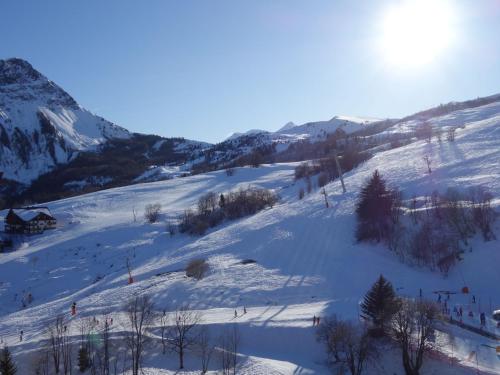 une piste enneigée avec des arbres et une montagne dans l'établissement Apartment Pegase Phenix-74 by Interhome, au Corbier