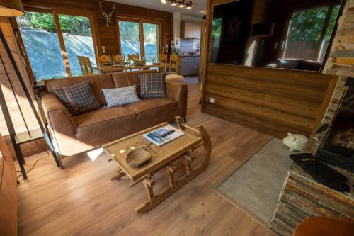 un salon avec un canapé et une table dans l'établissement Chalet des Anges with outside hot tube !, à Méribel