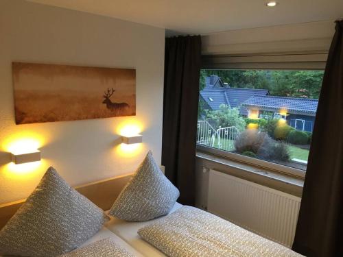 a bedroom with a bed with two pillows and a window at Goethestraße Ferienhaus in Bad Harzburg