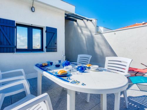 una mesa blanca y sillas en un patio en Apartment Duplex Ortal by Interhome en Lacanau