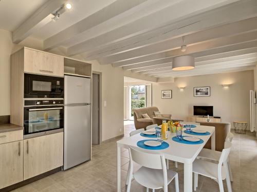 a kitchen and living room with a white table and chairs at Holiday Home Les Agapanthes by Interhome in Saint-Gildas-de-Rhuys