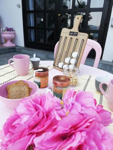 a table with a plate of food and pink flowers at Oasirelax -camera con vista a un passo da torino in Pavarolo
