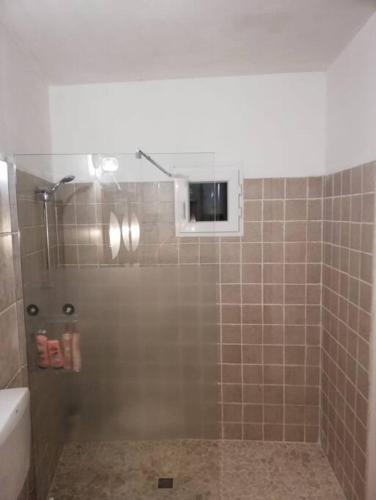 a bathroom with a shower with a tiled wall at Oasirelax -camera con vista a un passo da torino in Pavarolo