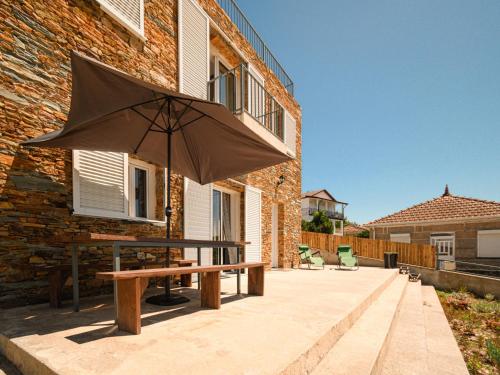 Holiday Home Douro view by Interhome في Melres: طاولة نزهة مع مظلة أمام المبنى