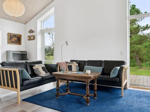 ein Wohnzimmer mit einem Sofa und einem Couchtisch in der Unterkunft Holiday Home Idda - 350m from the sea in NW Jutland by Interhome in Fjerritslev
