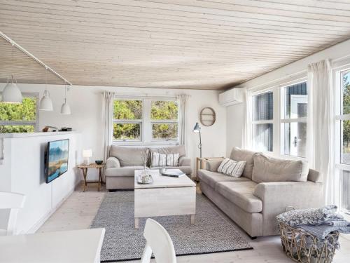 een woonkamer met een bank en een tafel bij Holiday Home Ofelia - 2-5km from the sea in NW Jutland by Interhome in Blokhus