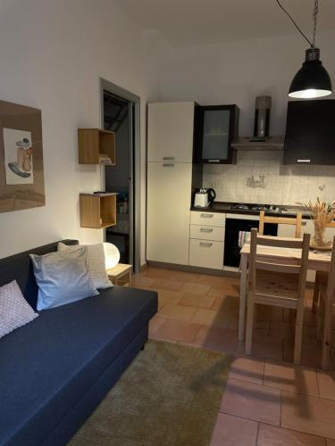 a living room with a blue couch and a kitchen at HOME BIJOUX in Rho