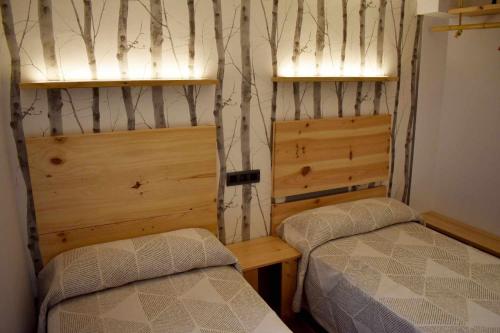 um quarto com 2 camas e 2 janelas em Casa Rural Puente Moneo em Garcibuey