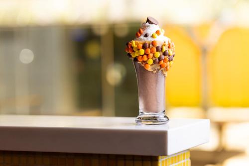 a chocolate milkshake with whipped cream and popcorn on a table at The Delphi Downtown LA in Los Angeles