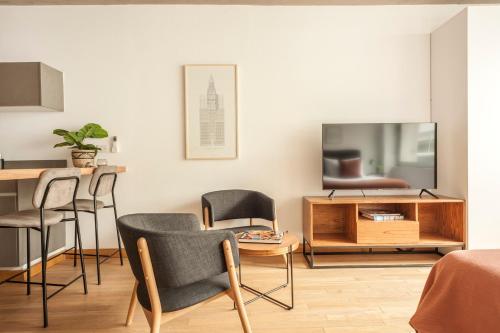 sala de estar con sillas, mesa y TV en Viví Buenos Aires en este Studio de Diseño #202 en Buenos Aires
