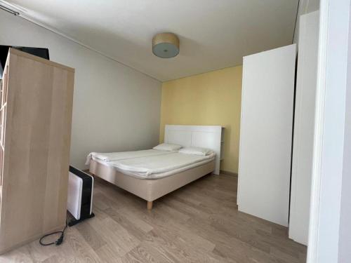 1 dormitorio pequeño con 1 cama y TV en Perlos Apartamentai 2A, en Birštonas