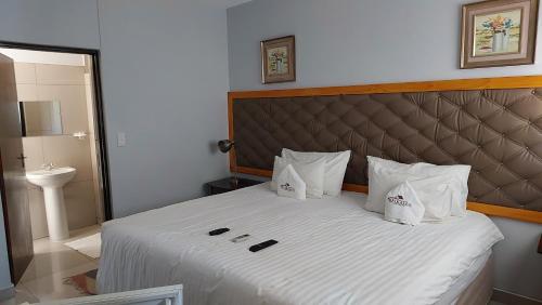 1 dormitorio con 1 cama blanca grande con almohadas blancas en Epikaizo Guest House, en Uutapi