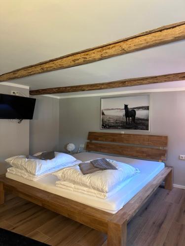 a bedroom with a bed with a picture of a horse on the wall at Allenberghütte Schoningen in Uslar