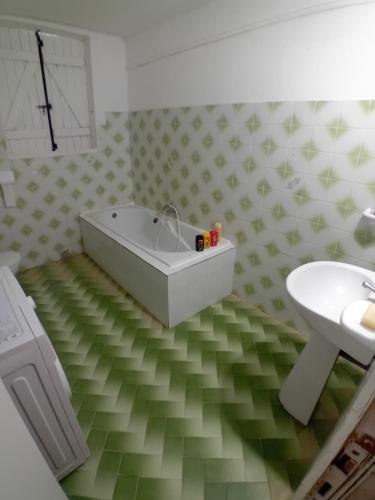 W łazience znajduje się biała wanna i umywalka. w obiekcie Résidence Mathurin w mieście Anse-Bertrand