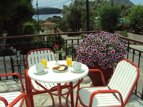 a white table and chairs with a breakfast on a balcony at Hotel Nostos in Nydri