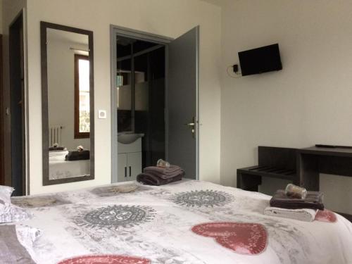 a bedroom with a large bed and a mirror at Eterlou in La Chambre