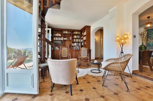 - un salon avec des chaises, une table et des étagères dans l'établissement La Casa San Biaggio, à Ajaccio