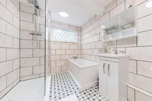 a bathroom with a shower and a sink and a toilet at Modern 4BD house with a private patio in Islington in London