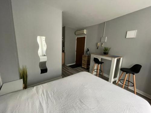 um quarto com uma cama branca e 2 cadeiras em Studio centre ville Bourges em Bourges