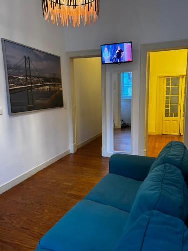 a living room with a blue couch and a flat screen tv at Fashion Chiado - SSs Apartments in Lisbon