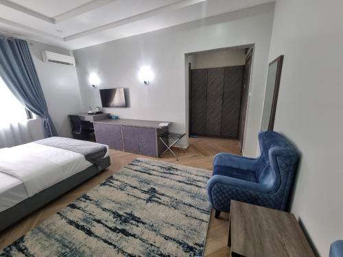 1 dormitorio con cama, silla y escritorio en Solace Suites and Homes Maiduguri en Maiduguri
