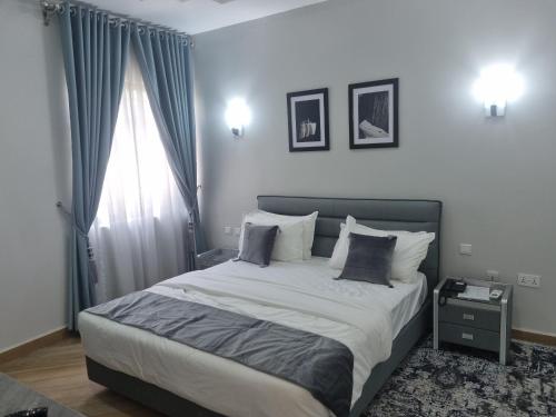 ein Schlafzimmer mit einem großen Bett und einem Fenster in der Unterkunft Solace Suites and Homes Maiduguri in Maiduguri
