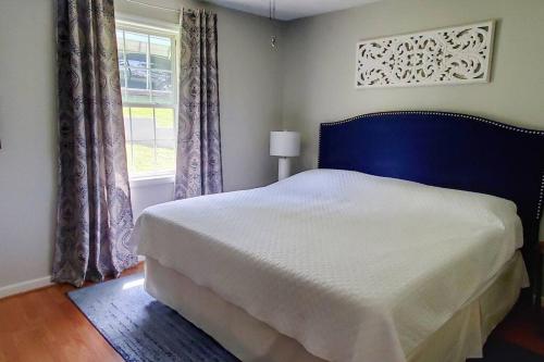 1 dormitorio con 1 cama con cabecero azul y ventana en The Great Escape - Lakefront Rental with Views en Inman
