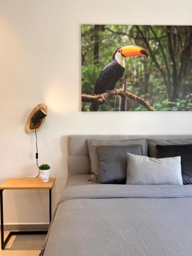 a picture of a bird sitting on a branch above a bed at White Door Apartments in Haifa