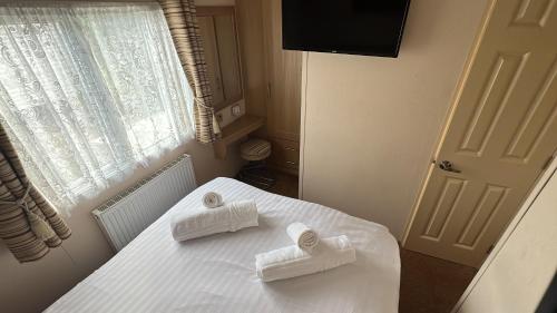 a bedroom with a bed with towels on it at 3 Bedroom, 6 Berth, Dog Friendly, Holiday Home in Belton