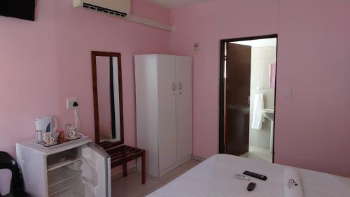 a bedroom with a bed and a large mirror at Epikaizo Guest House in Uutapi