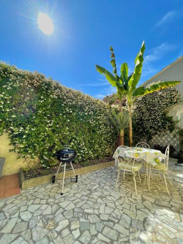 eine Terrasse mit einem Grill, 2 Stühlen und einem Tisch in der Unterkunft Viareggio ampia casa con giardino in Viareggio