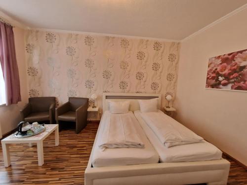 sypialnia z łóżkiem, krzesłem i stołem w obiekcie H5 Hotel Bremen w Bremie