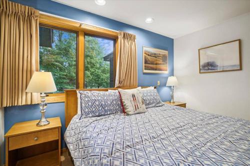 - une chambre avec un lit aux murs bleus et une fenêtre dans l'établissement Captivating Condo, 1 bedroom with loft, sleeps 6, sports center Highridge E10, à Killington