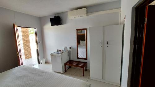 1 dormitorio con cama, espejo y tocador en Epikaizo Guest House, en Uutapi