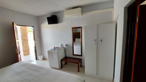 a bedroom with a bed and a mirror and a dresser at Epikaizo Guest House in Uutapi