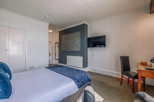 a bedroom with a bed and a desk and a desk at Muthu Westcliff Hotel (Near London Southend Airport) in Southend-on-Sea