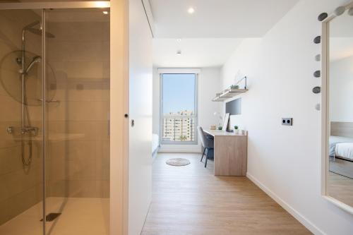 Habitación con baño con ducha y escritorio. en Micampus Barcelona, en Barcelona