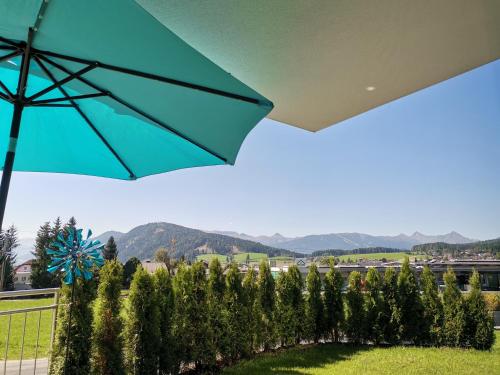 a blue umbrella over a row of trees at Berg:Zeit_Apartments in Tamsweg