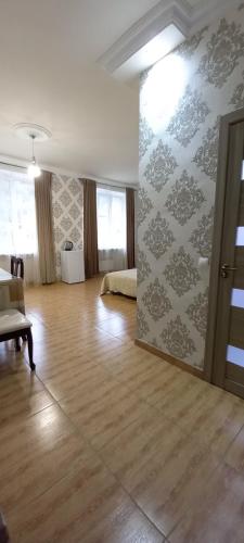 a living room with a room with a wooden floor at ApartHotel in Alaverdi in Alaverdi