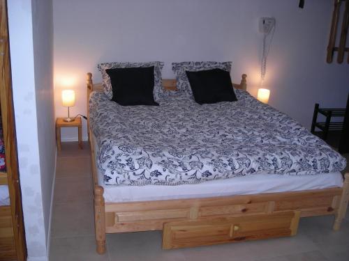 a bedroom with a large bed with black pillows at Iglika 2 - Studio Cabin in Borovets