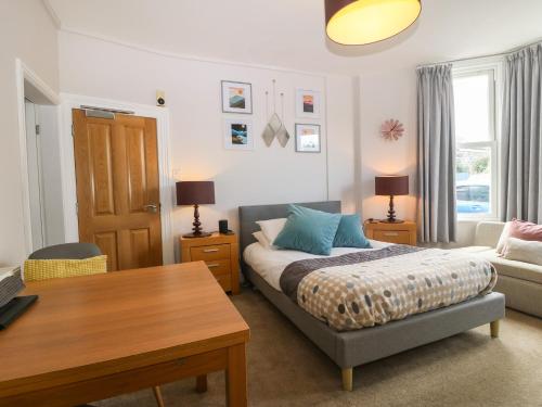 sypialnia z łóżkiem, stołem i kanapą w obiekcie Y Castell Apartment 1 w mieście Criccieth