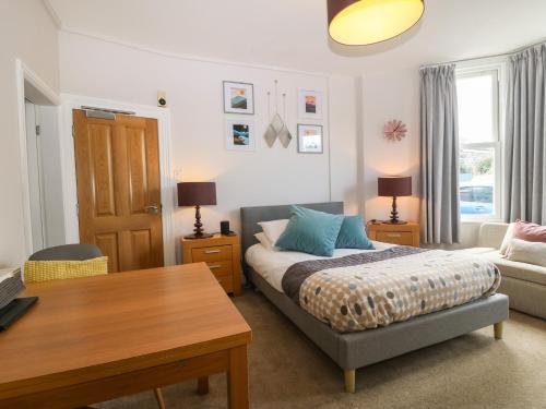 Un dormitorio con una cama, una mesa y un sofá. en Y Castell Apartment 1, en Criccieth